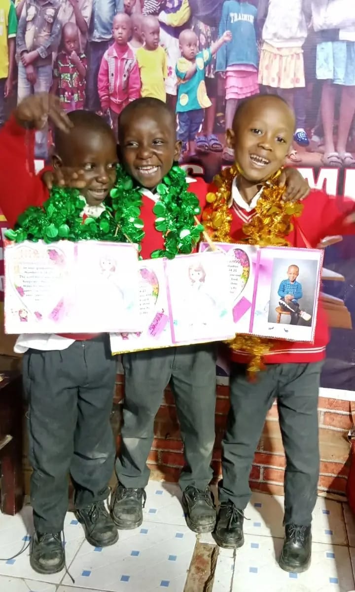 Three boys celebrating their graduation with garlands