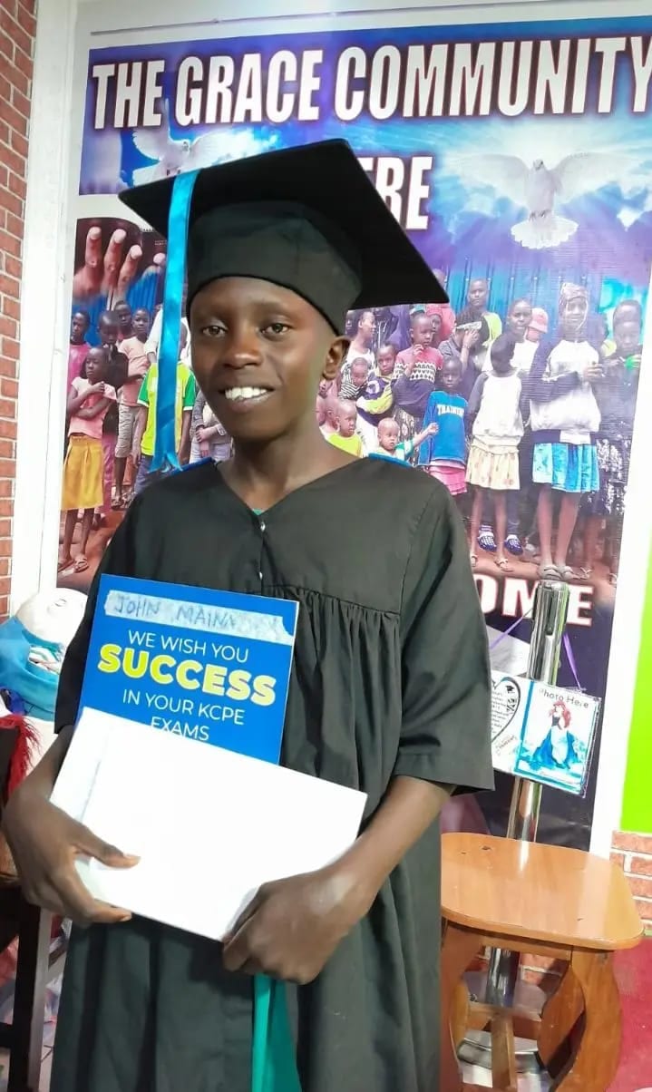 A graduate in cap and gown wished success in his KCPE exams