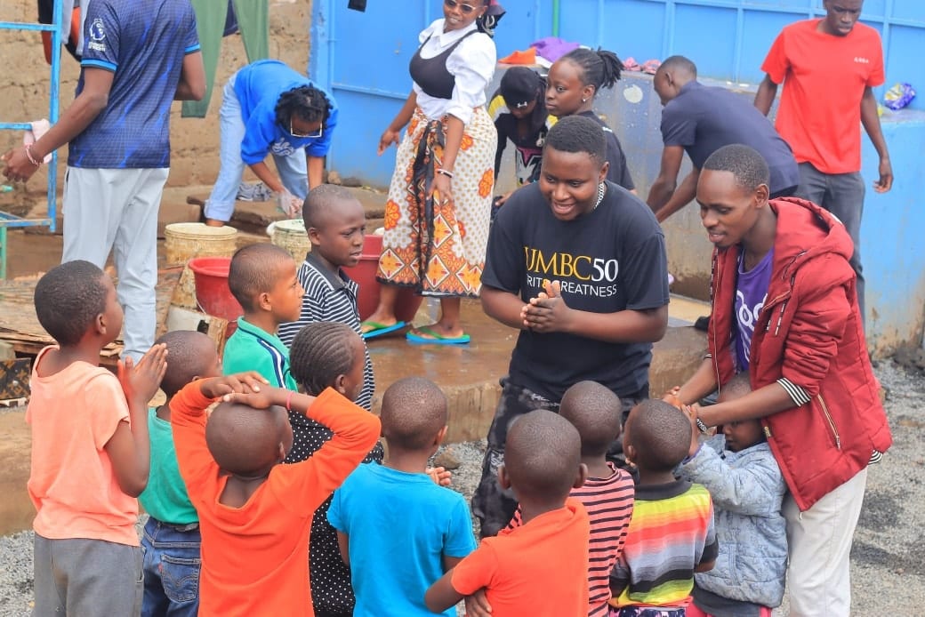 Volunteers playing with a group of children outdoors