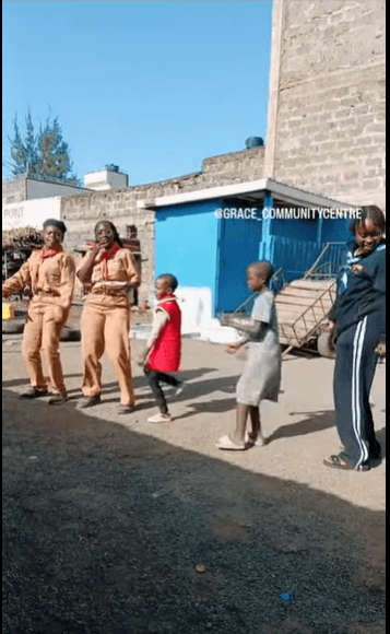 Children and caregivers dancing in the yard