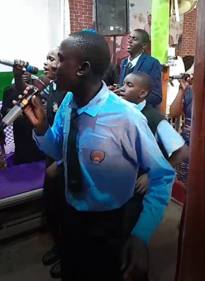 Boys in uniform singing during fellowship